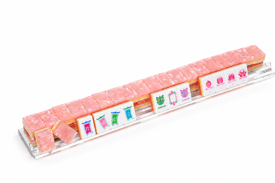 Mahjong tile set in a row on clear base, peach-pink tiles with printed faces