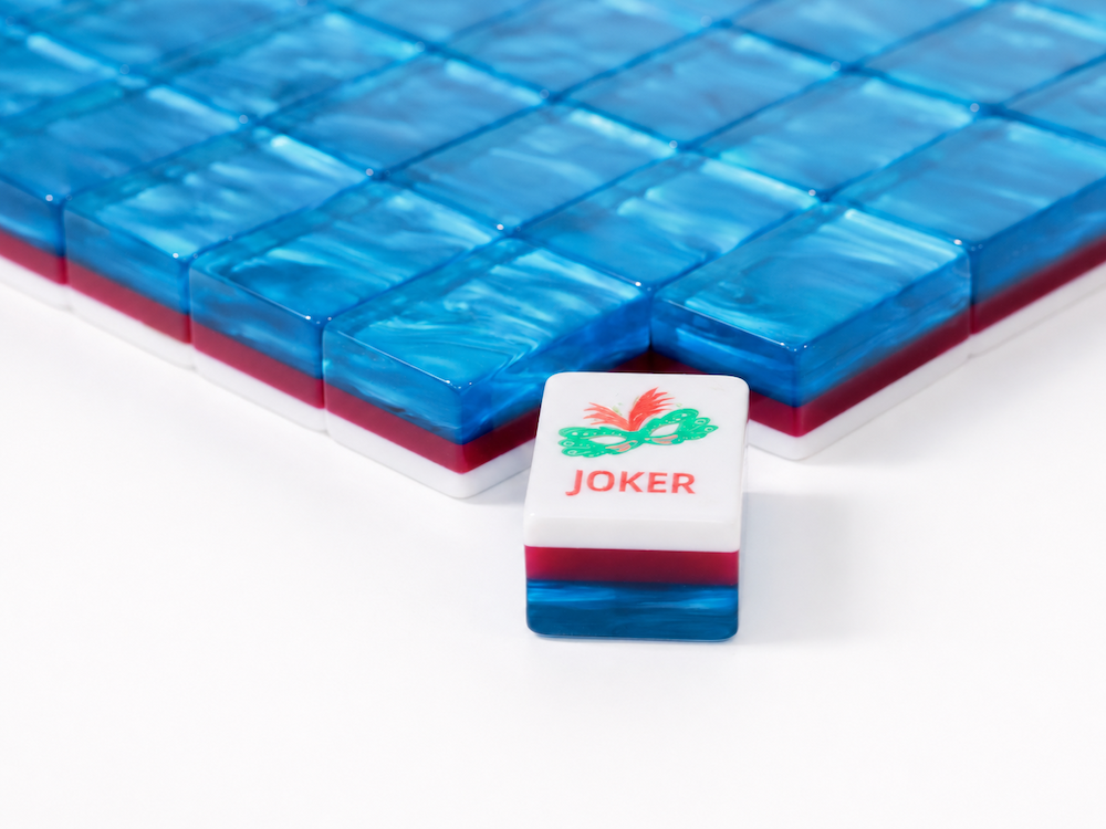 Azure Tide mahjong tile set close-up with joker tile placed on a glossy blue tile stack.