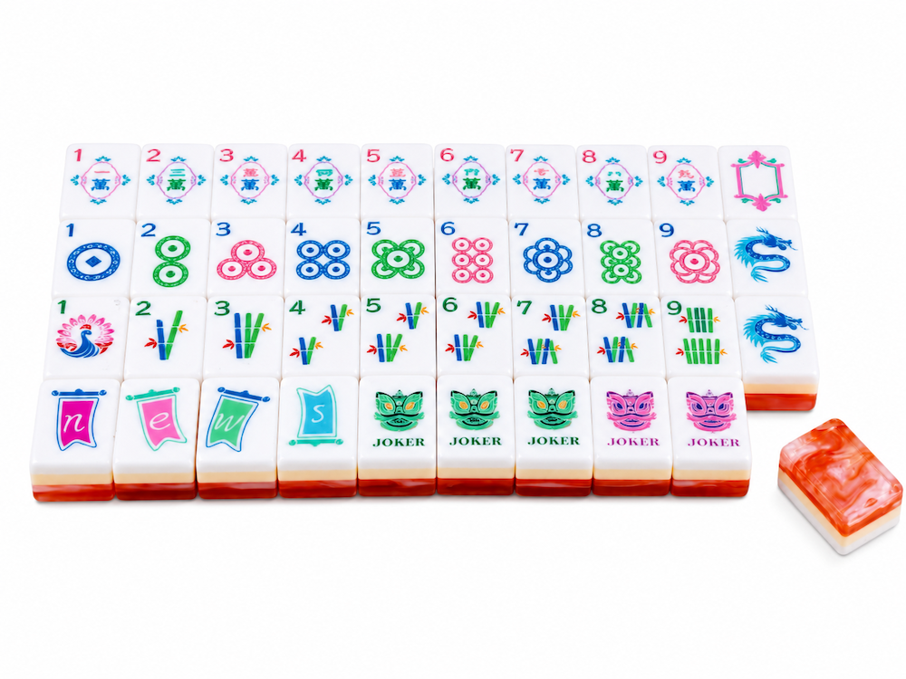Mahjong tile set with white tiles, colorful number dots, and joker tiles; coral tile stack nearby