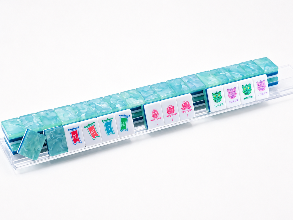Jade blue translucent Mahjong tile set with colorful suit and dragon joker faces in tray