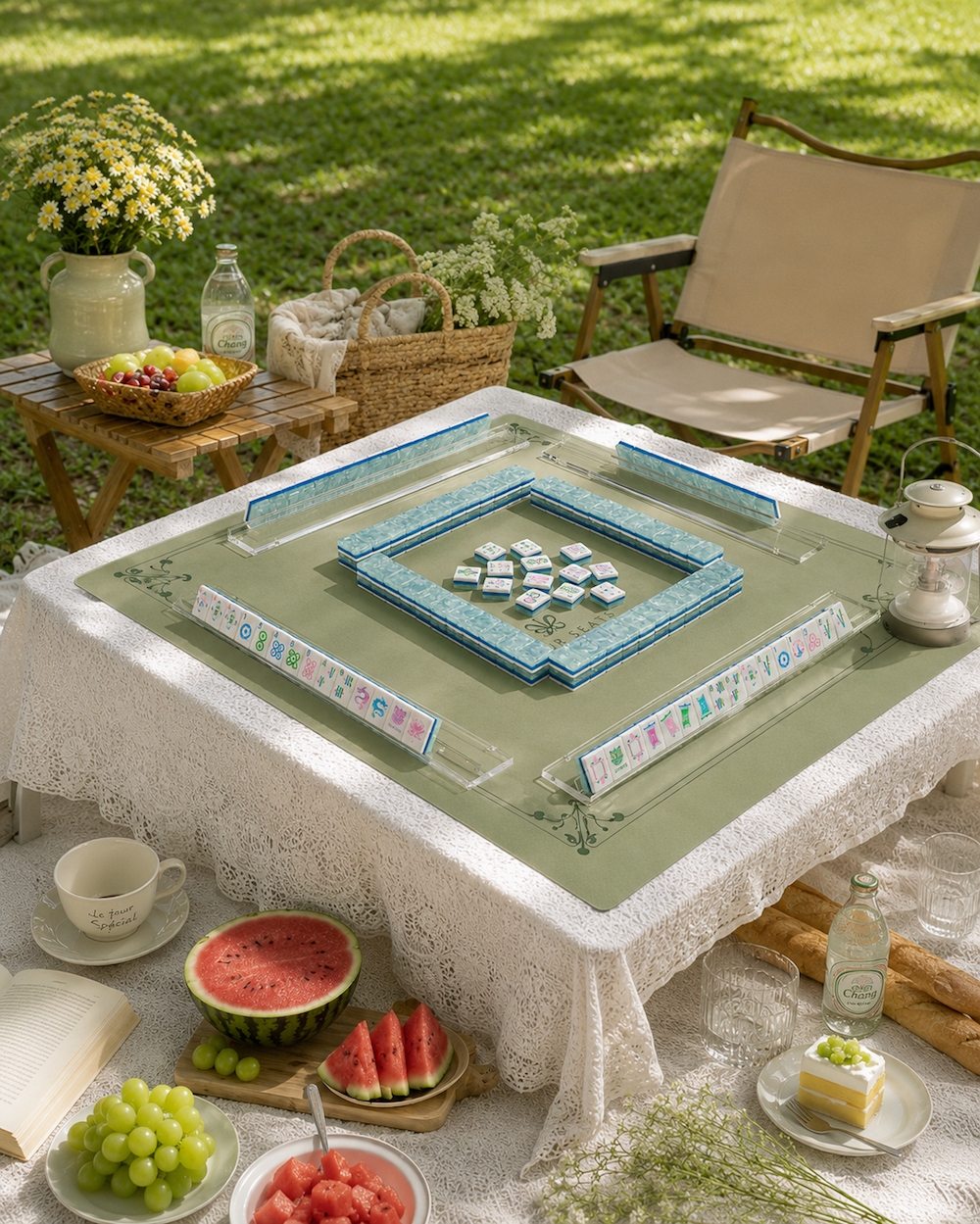 Outdoor mahjong table with green cloth and arranged blue tiles in tray