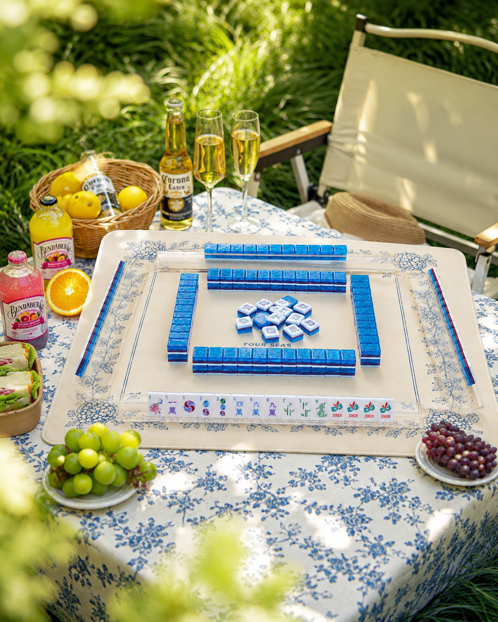 Mahjong table with blue tiles, card rack, and dice on a patterned cloth