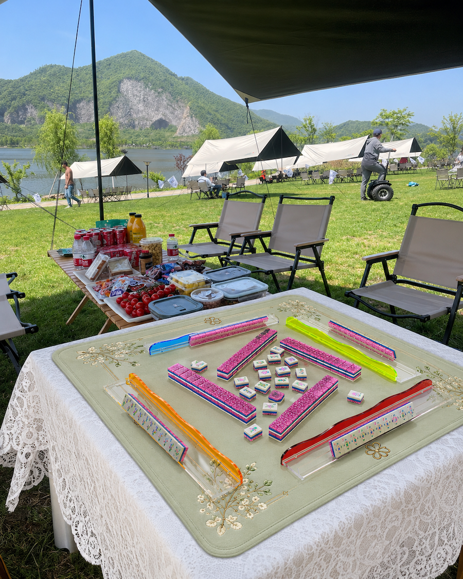 Mahjong tile set displayed on outdoor table with pink stardust pieces