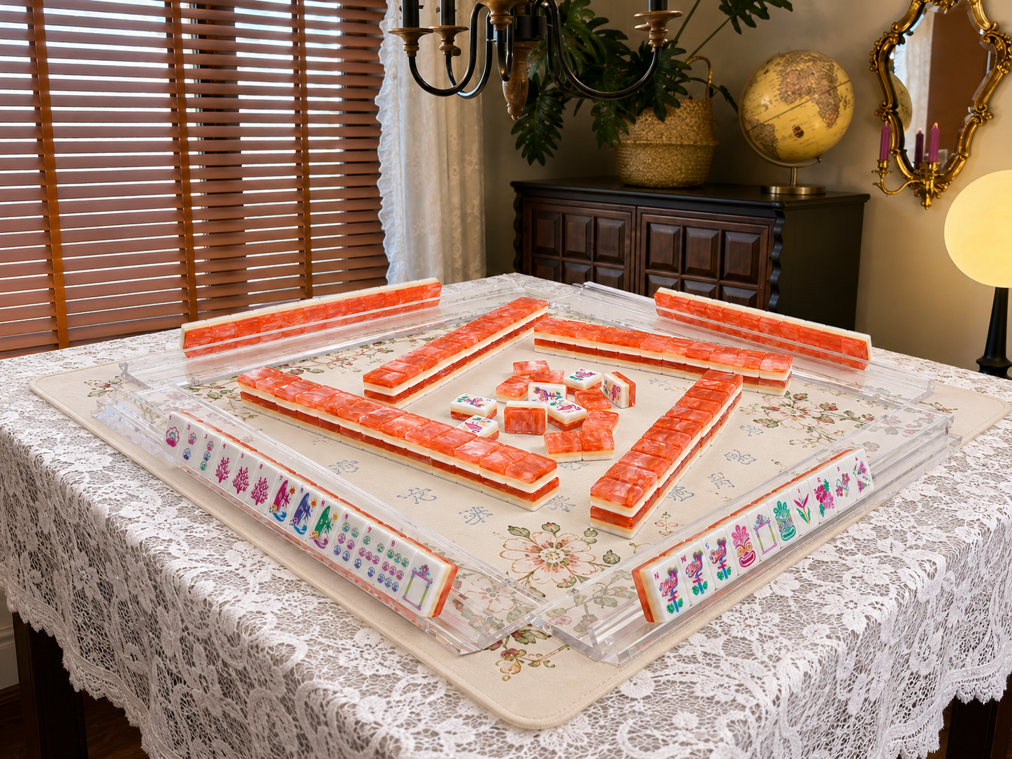 Mahjong tile set on lace tablecloth with coral-orange tiles and floral border board