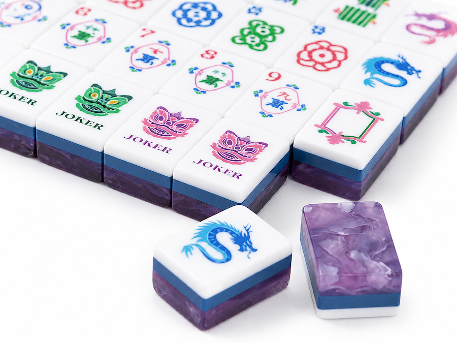 Close-up of white mahjong tiles with multicolor symbols and purple-backed edges