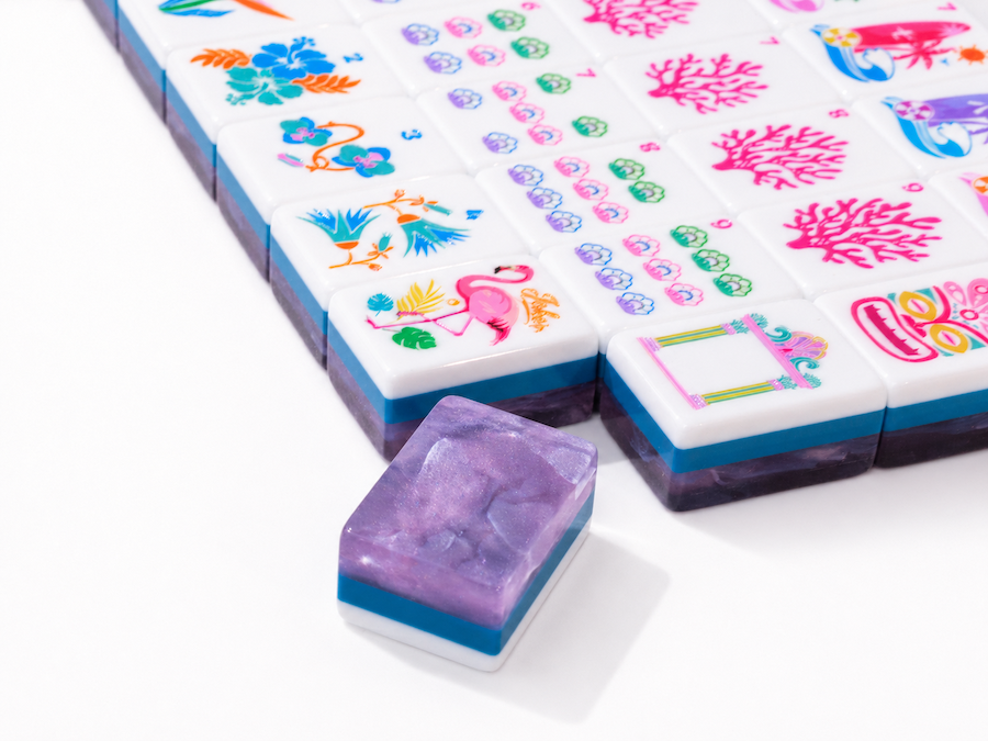 Mahjong tiles with close-up faces, separated single tile in front