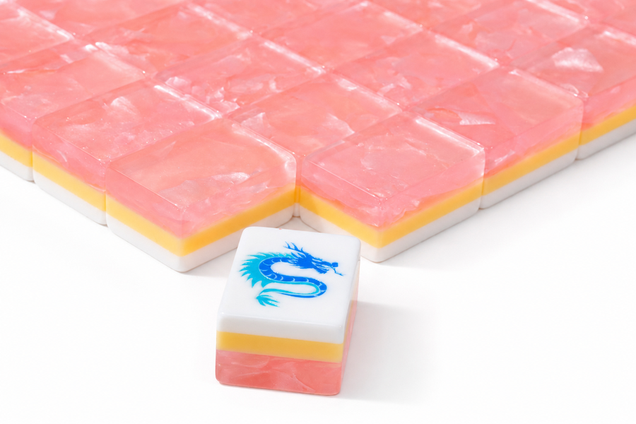Mahjong tile set corner close-up with peach-pink tiles and a blue dragon mark