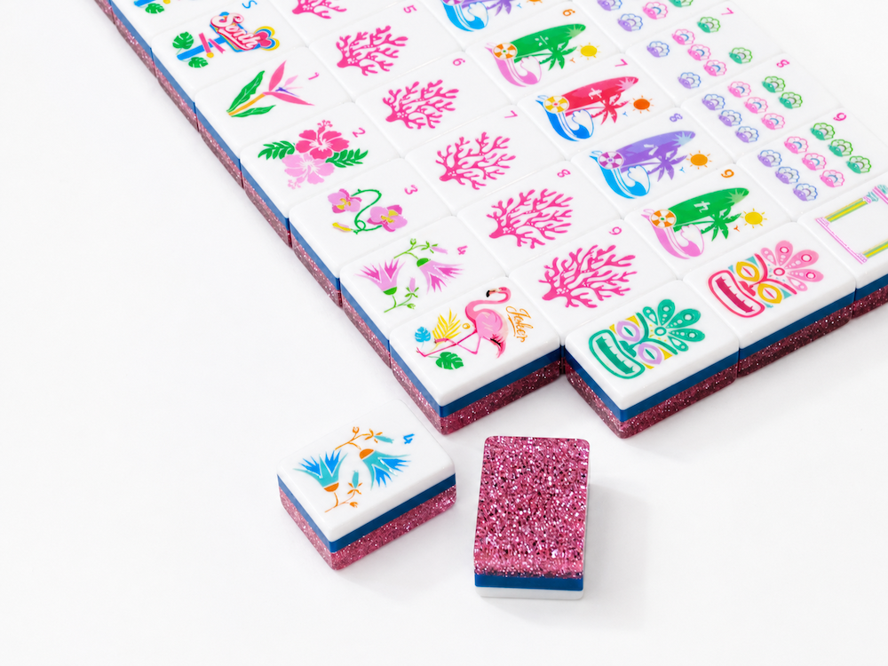Pink stardust mahjong tiles laid on a tray, showing glittery borders and illustrations