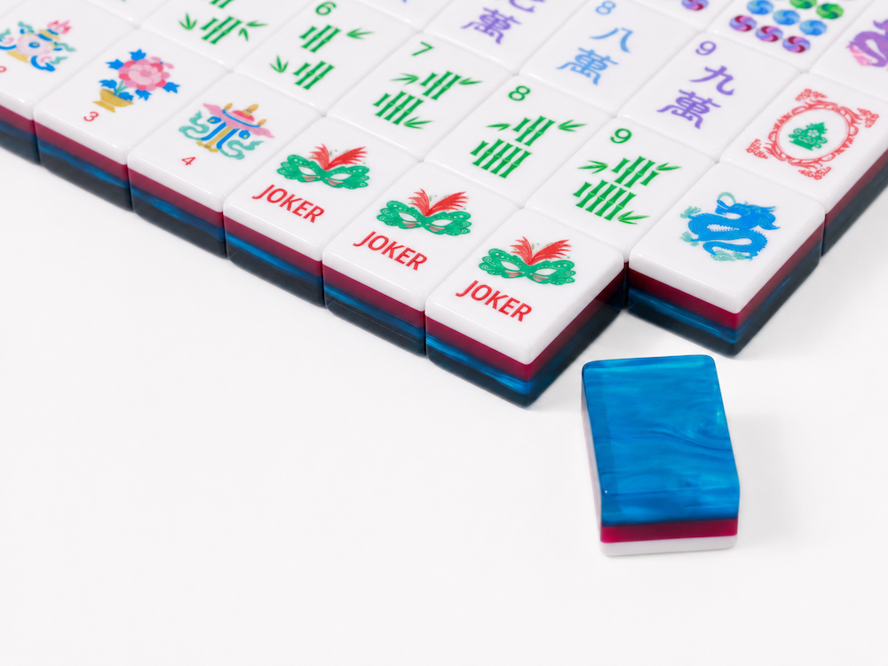 Azure Tide mahjong tile set corner close-up with stacked blue tiles and a joker tile.