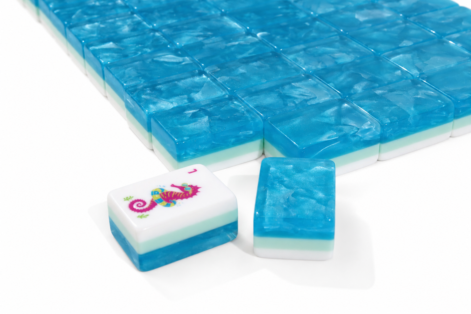 Close-up of blue mahjong tiles with white edges and colorful icon insets