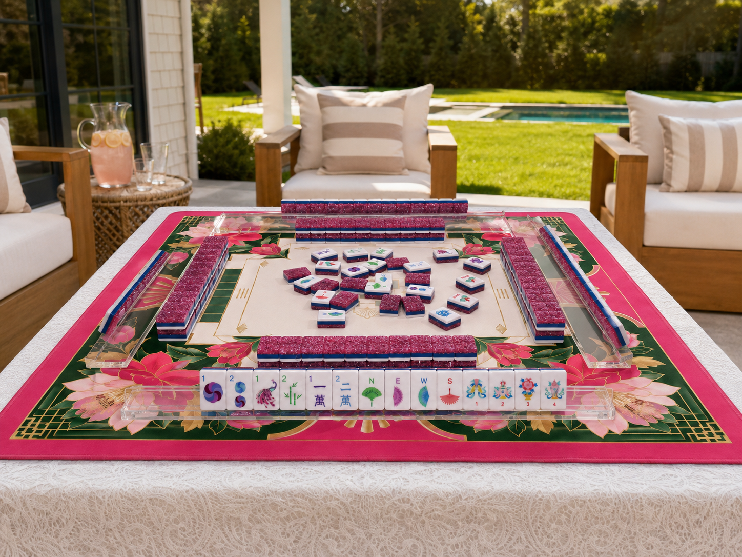 Pink Stardust American Mahjong tiles arranged for play on a floral mat beside a pool