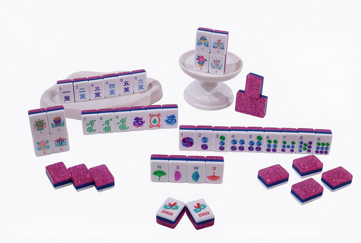 The Parlor Table Pink Stardust Mahjong tiles arranged with colorful faces and sparkling pink backs