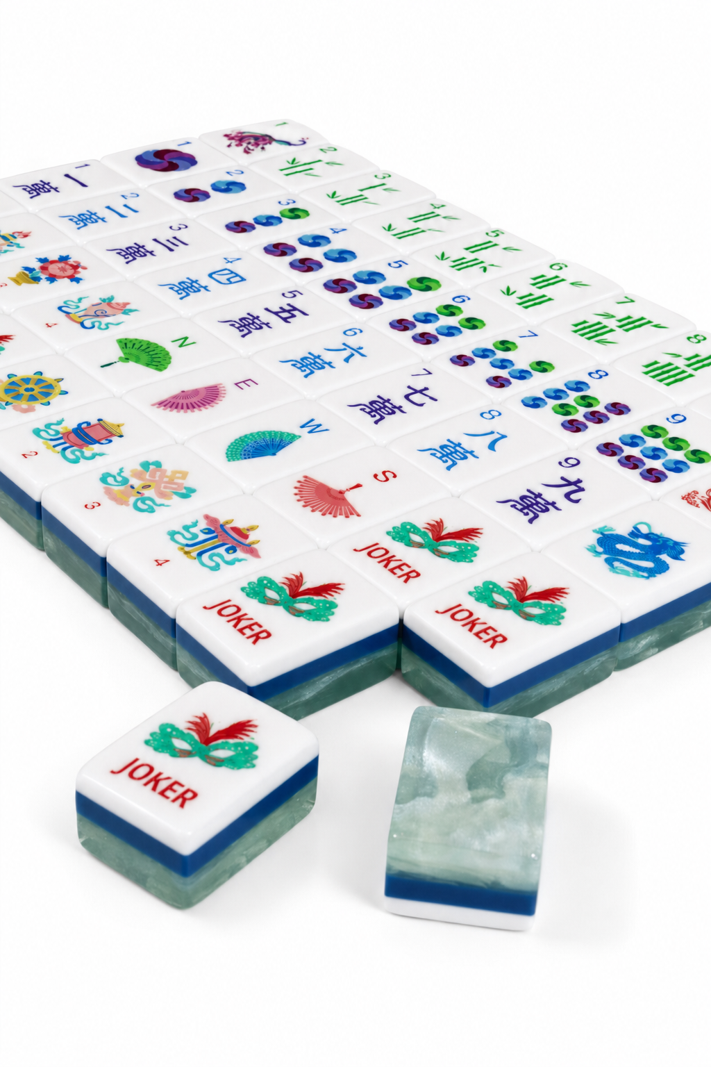 Close view of mahjong tiles with white faces, colorful symbols, and jade-green base tiles